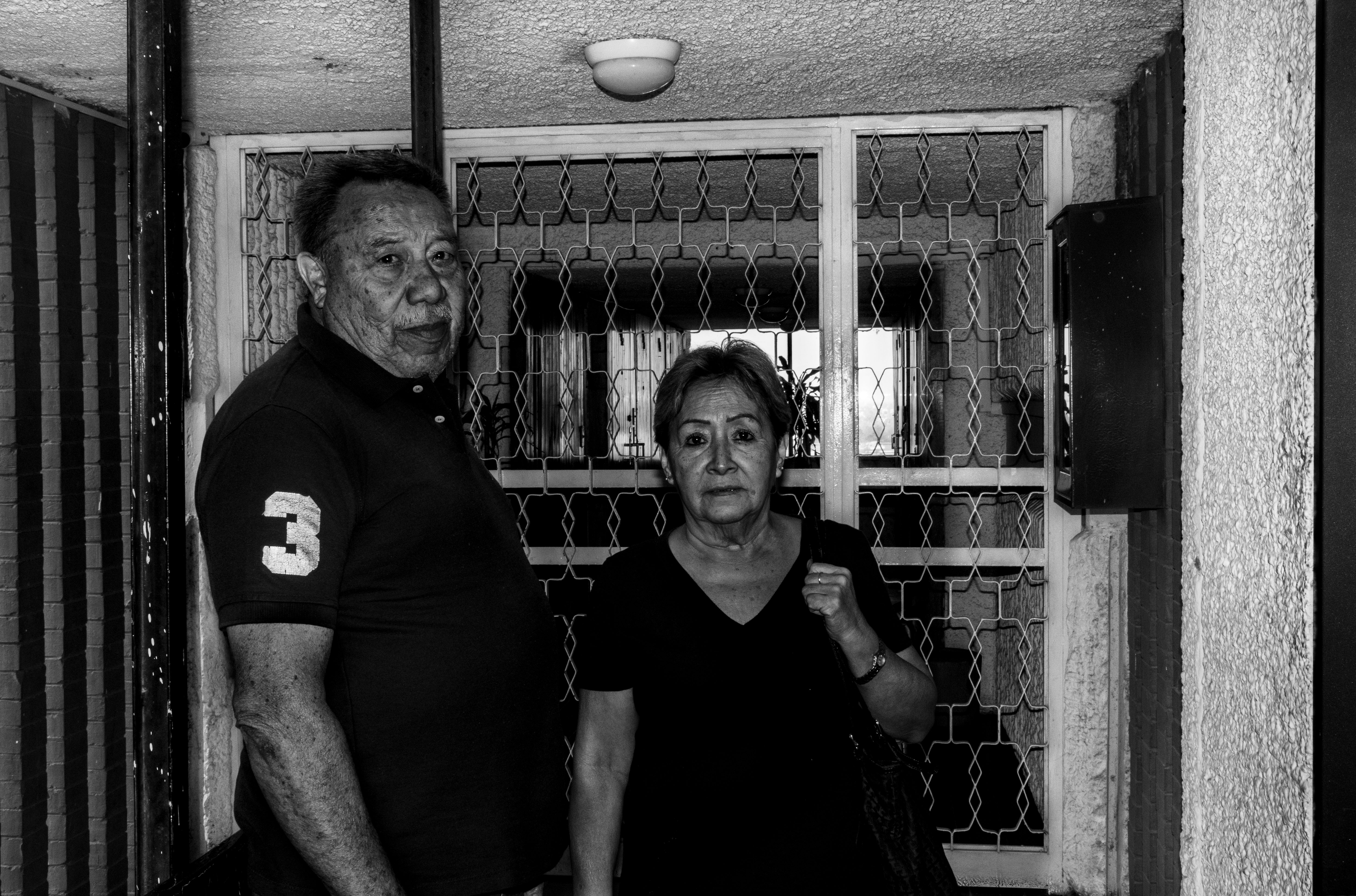 Del sur — Pareja de vecinos retratados en el pasillo de la unidad